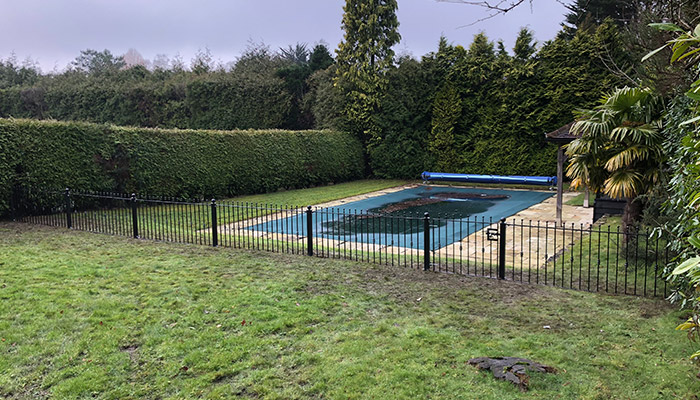 Metal safety gate and railing to protect swimming pool